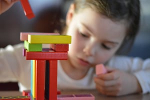 Young girl explores scientific thinking as she builds with blocks
