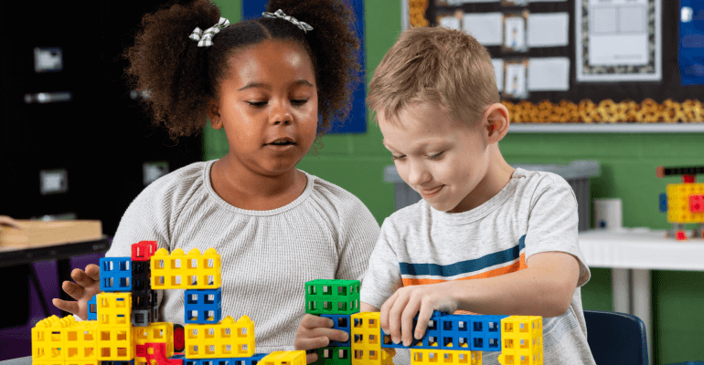 An elementary school age female student and male student working together with hands-on blocks to learn STEM